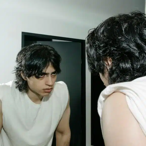 An angry man looking at himself in the mirror.