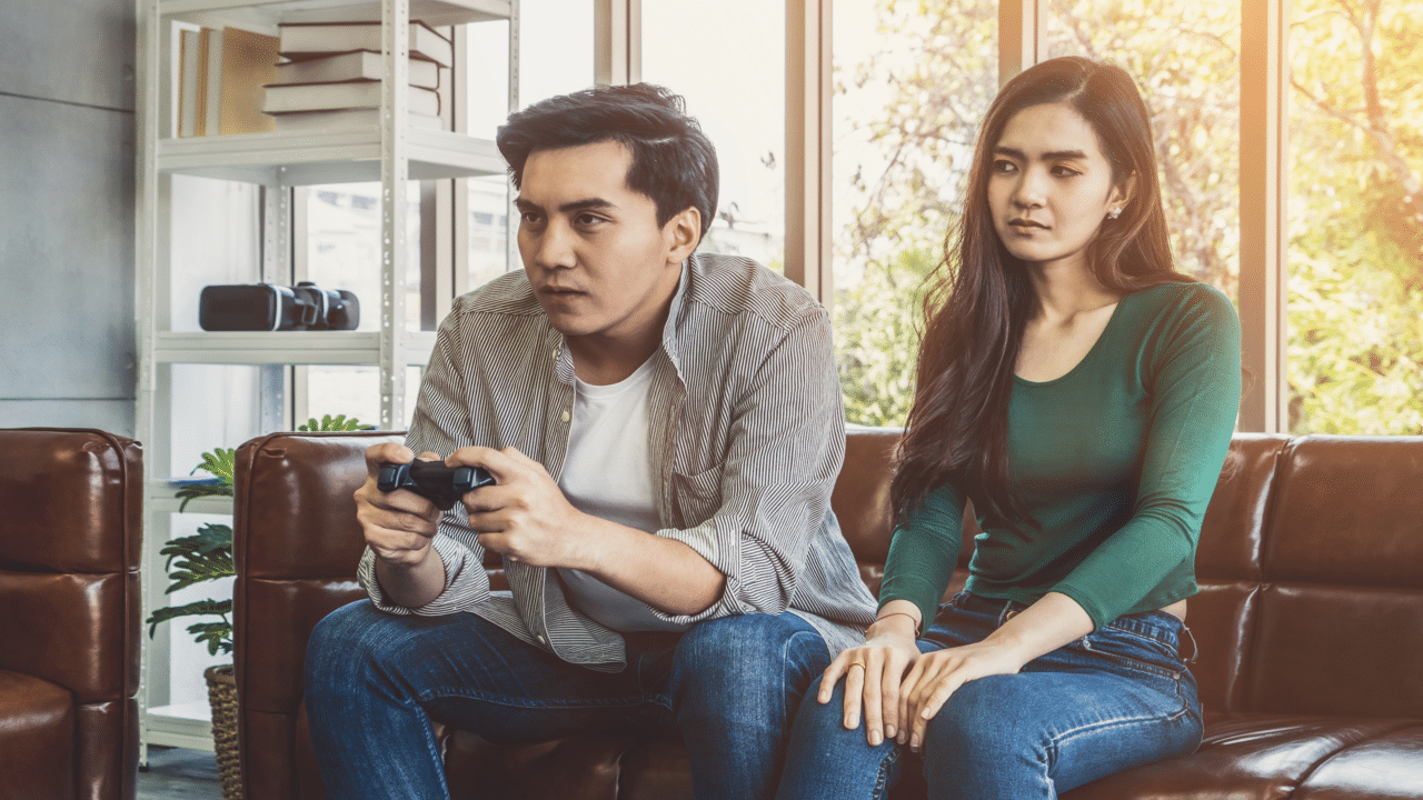 A man ignoring his wife to play a video game