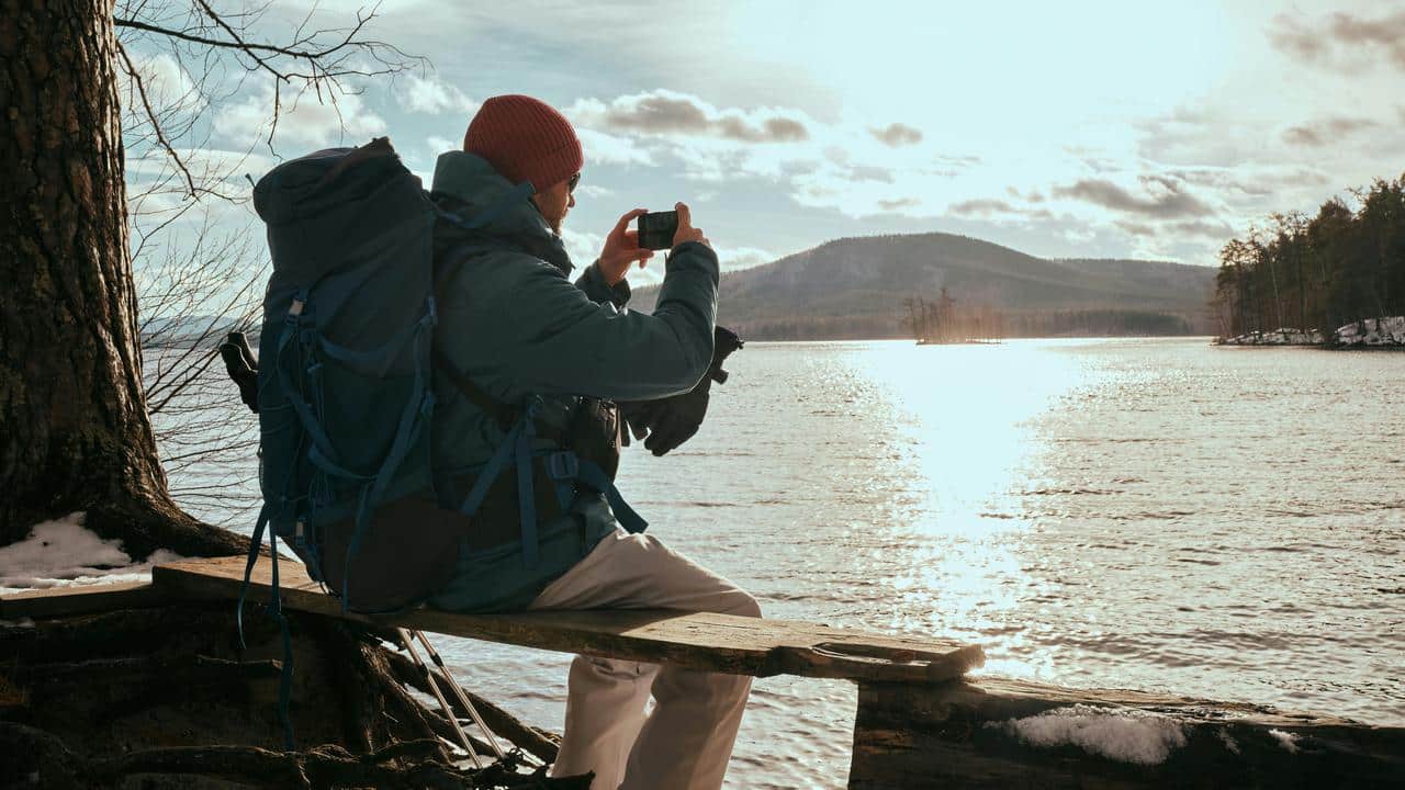 A backpacker sitting by a lakeside