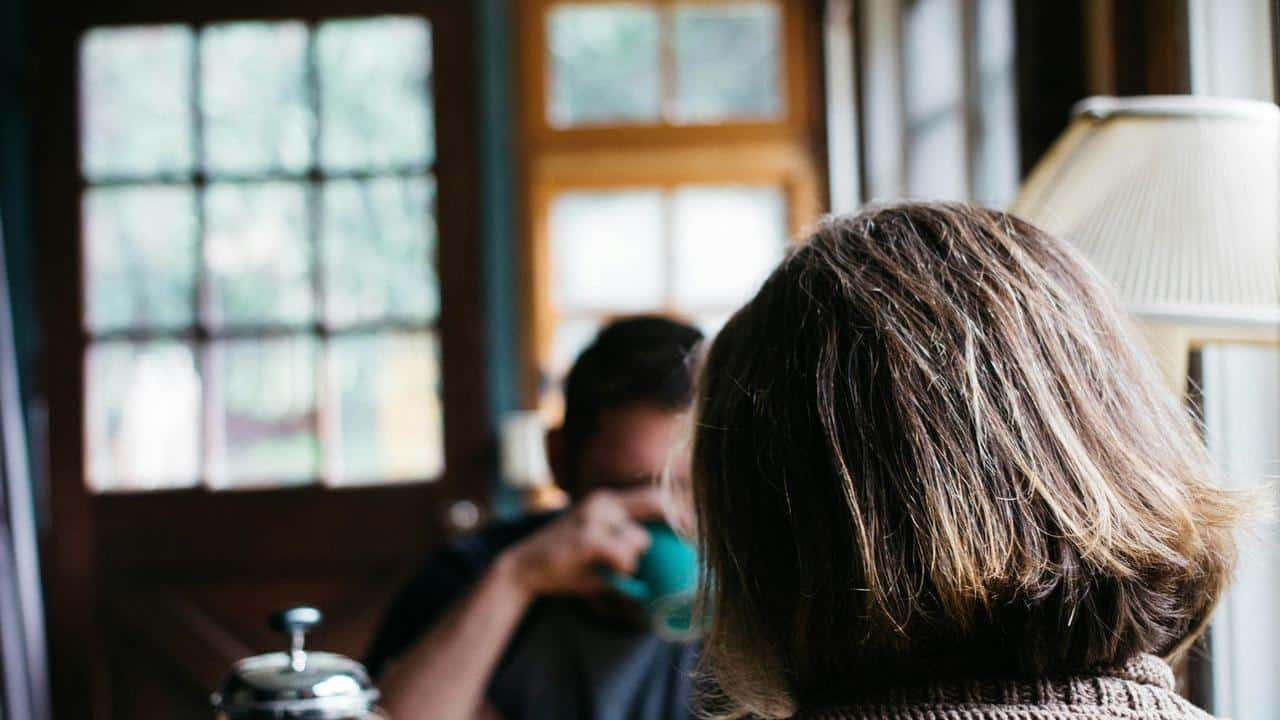 A person sitting indoors with another person