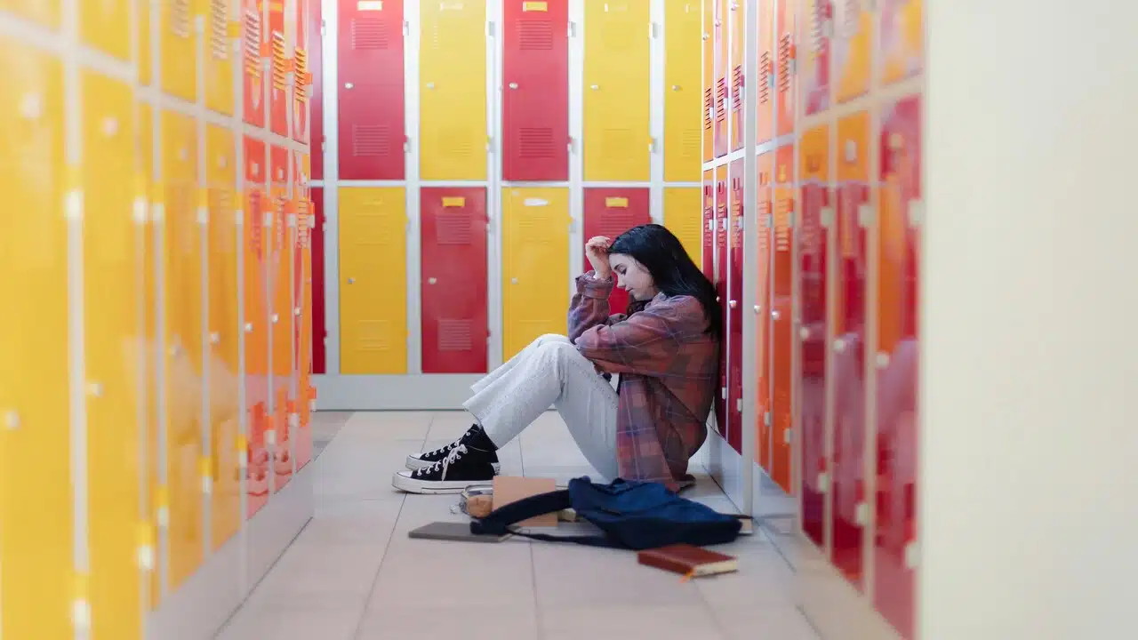 A woman looking sad by her locker