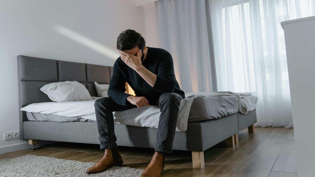 A man looking sad in bed