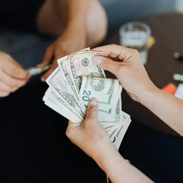 A person counting U.S. dollar bills