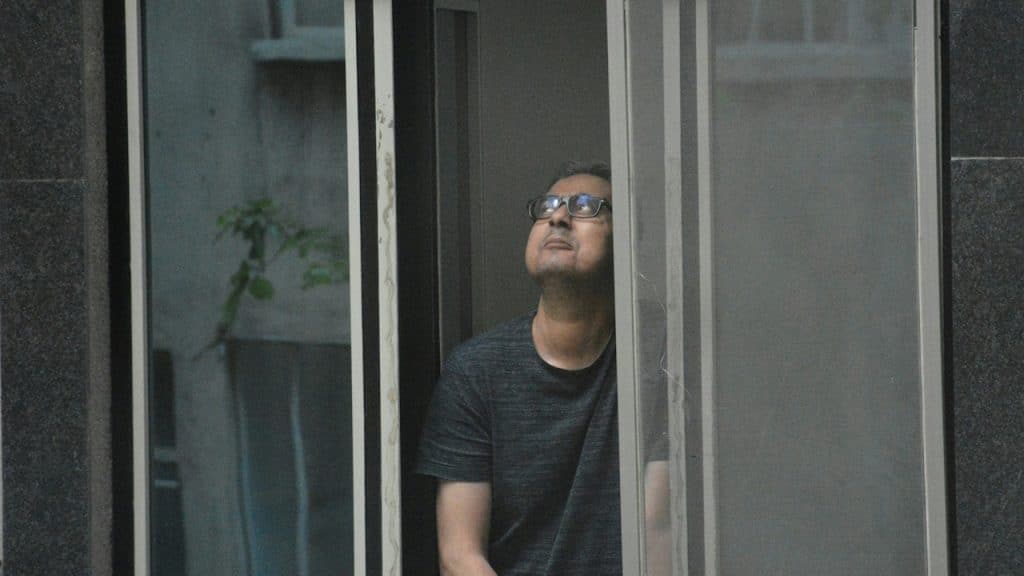 A man looking out of a window in a building.