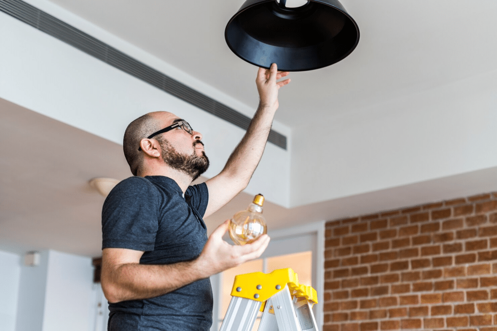 A man changing light bulb