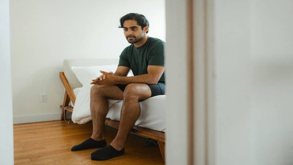 man sitting quietly in bedroom