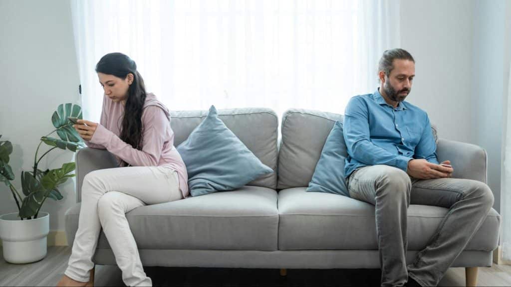 A man and woman using their own phone