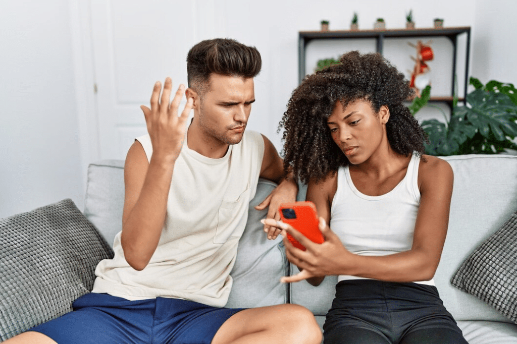 Man and woman couple with problems using smartphone at home