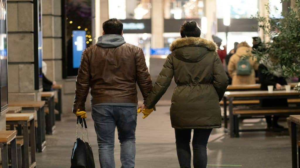 couple holding hands while walking