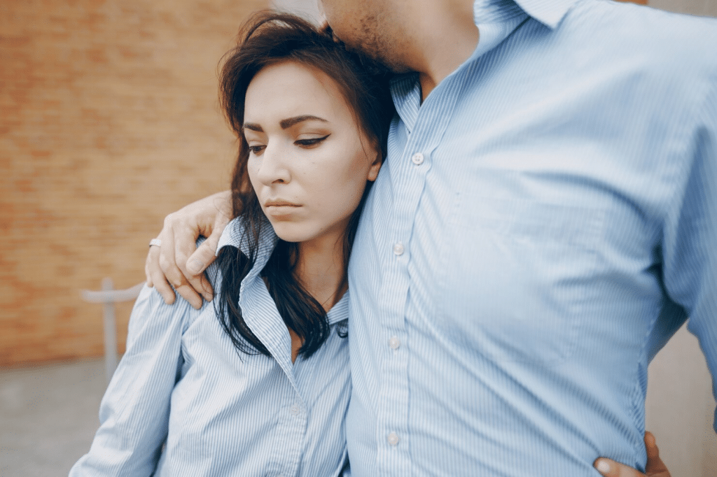 Man hugging a sad woman