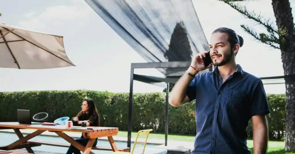 A man smiling while talking on a phone