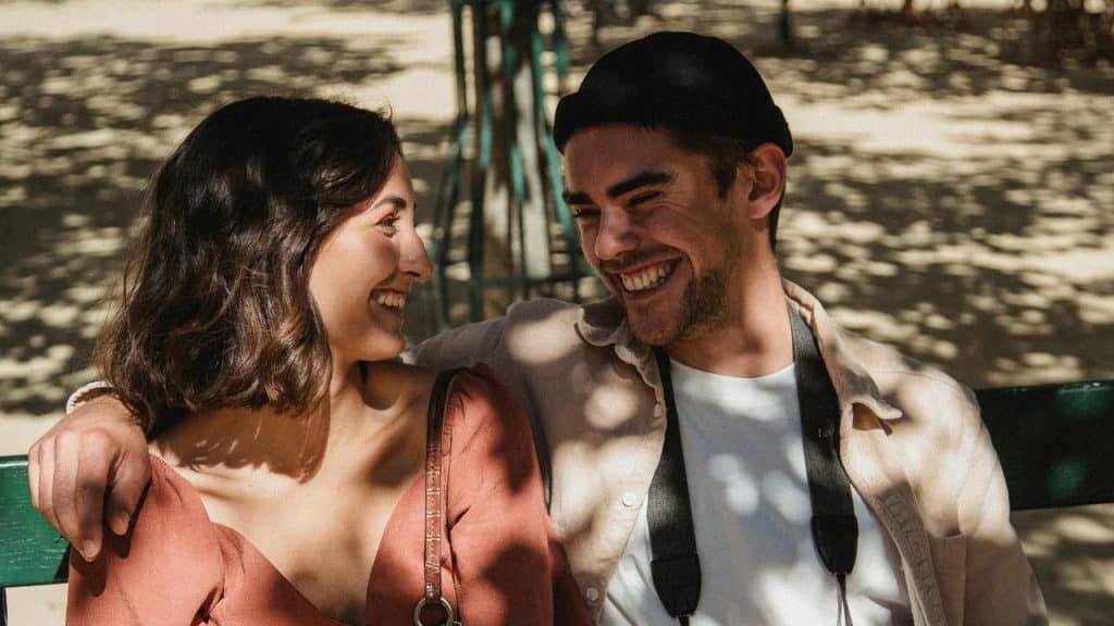 A smiling couple sitting on a bench