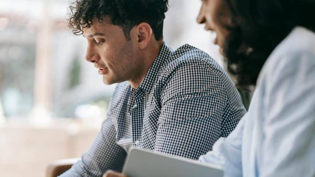 A man and woman looking at a laptop together.