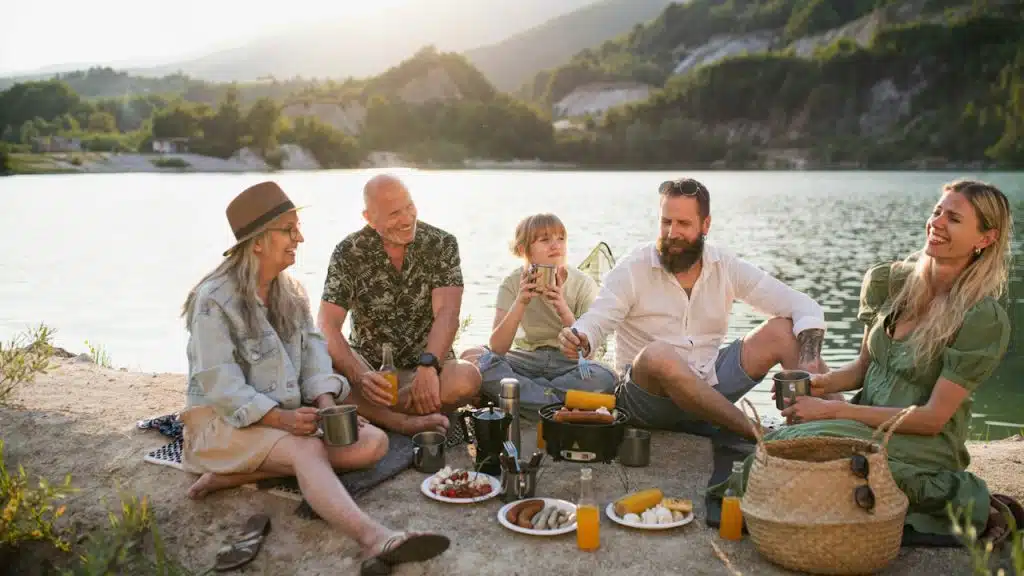 A happy multigeneration family on a summer holiday trip barbecue by the lake