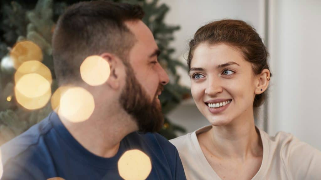 A couple smiling while looking at each other.