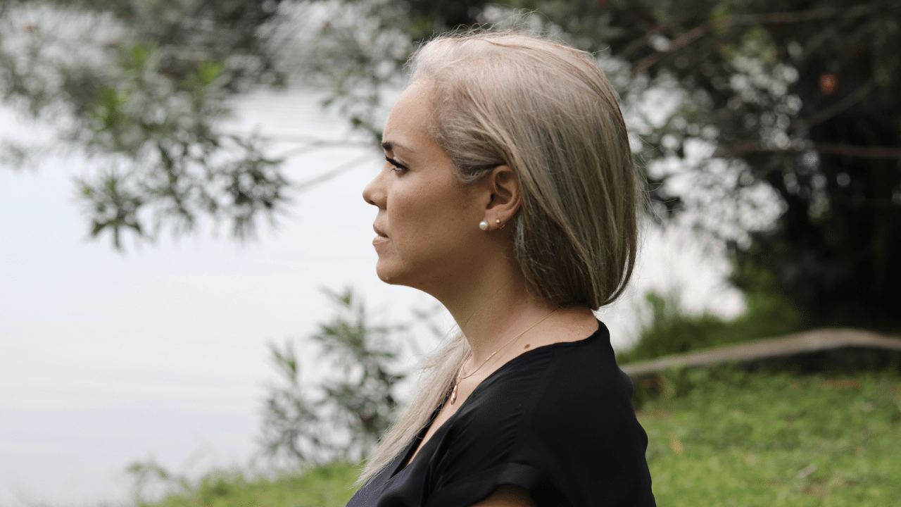 A woman looking upset by a body of water