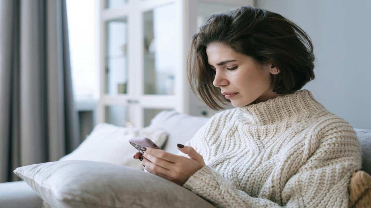 A woman looking sad while texting