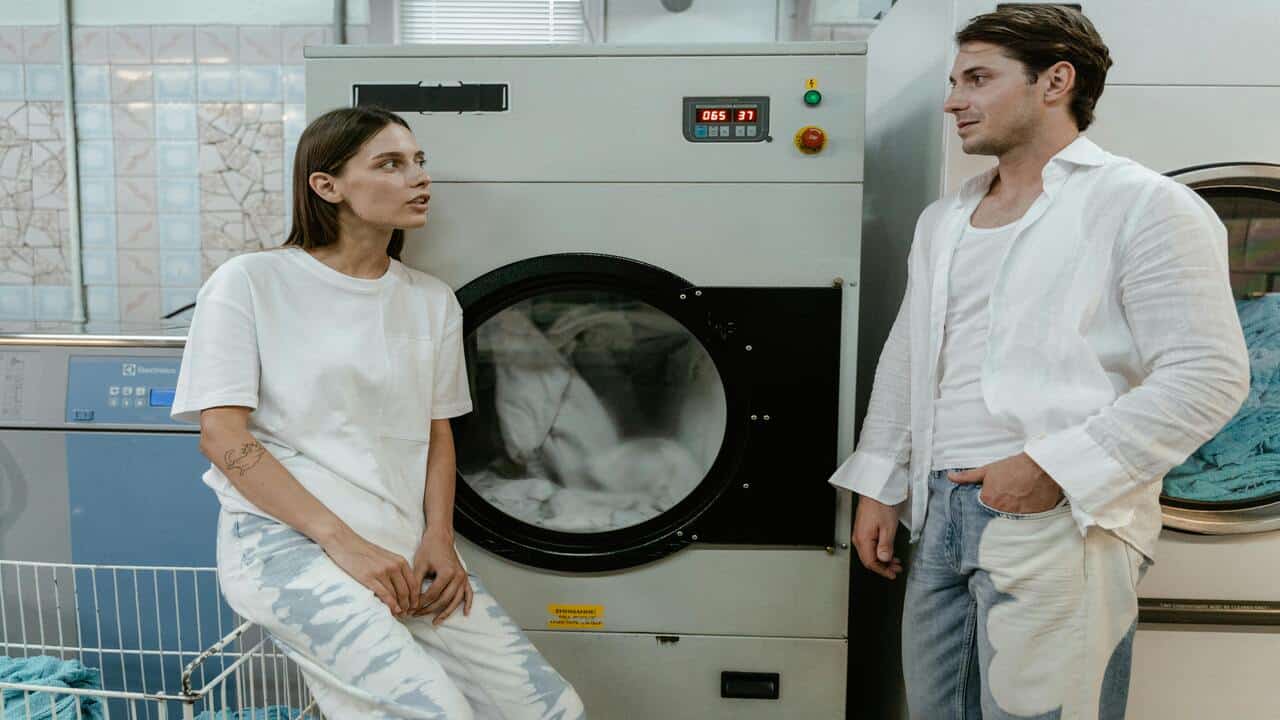 A couple talking while doing the laundry