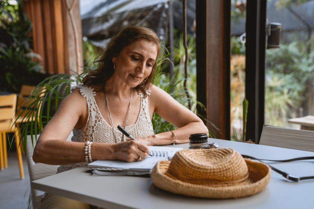 Woman 40s in Lace Top Writing on Notebook
