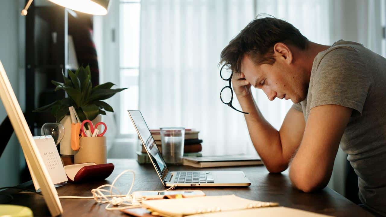 A man leaning over a desk with a laptop