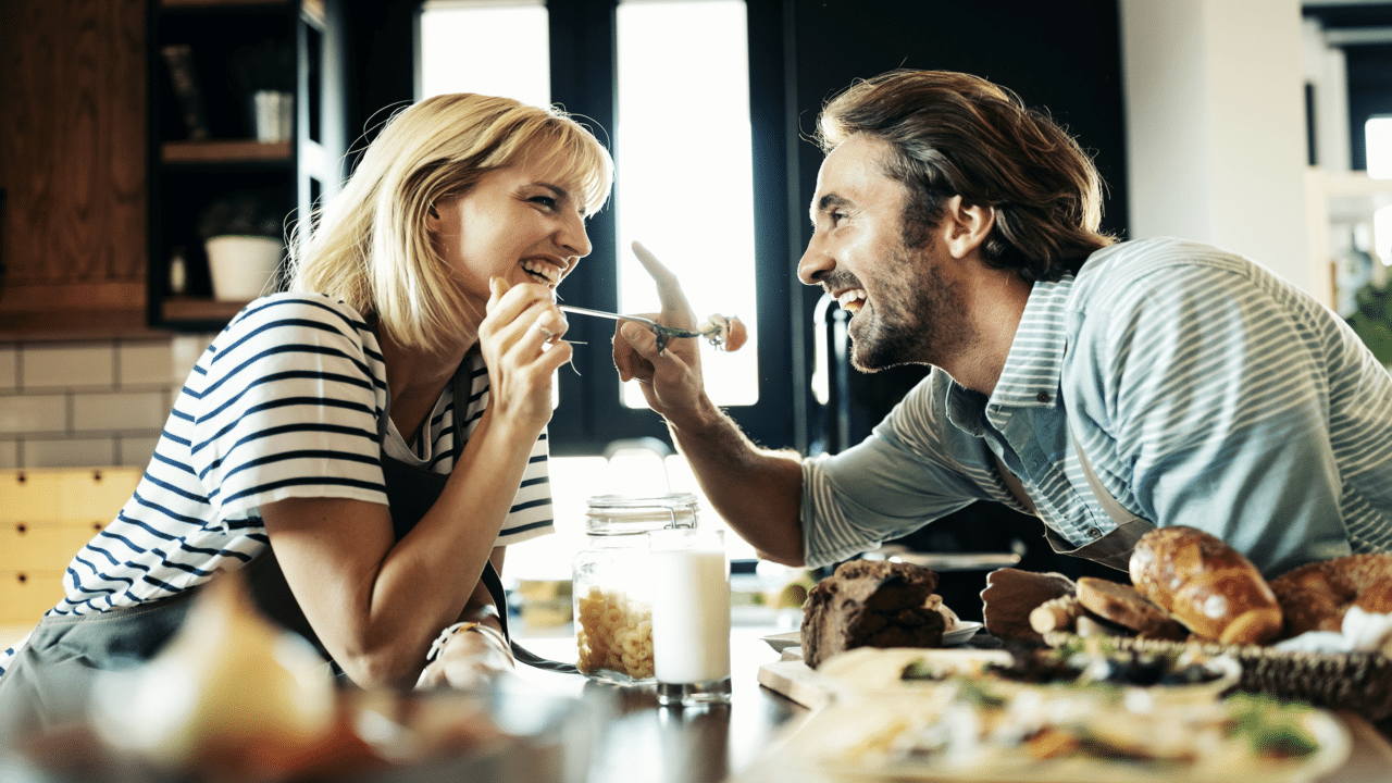 A couple laughing together in the kitchen