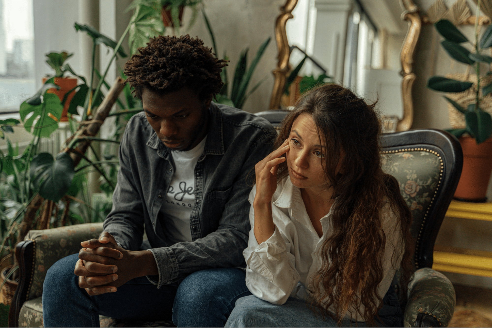 Unhappy Couple Sitting Next to Each Other on a Couch