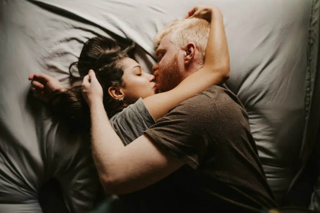 A couple kissing in bed