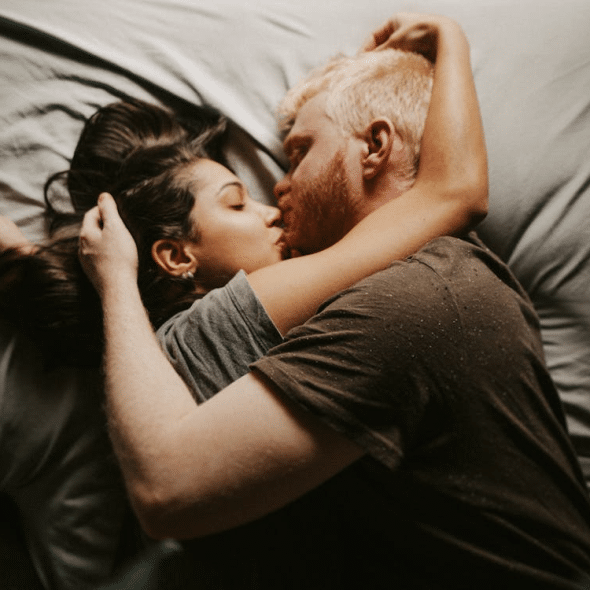 A couple kissing in bed