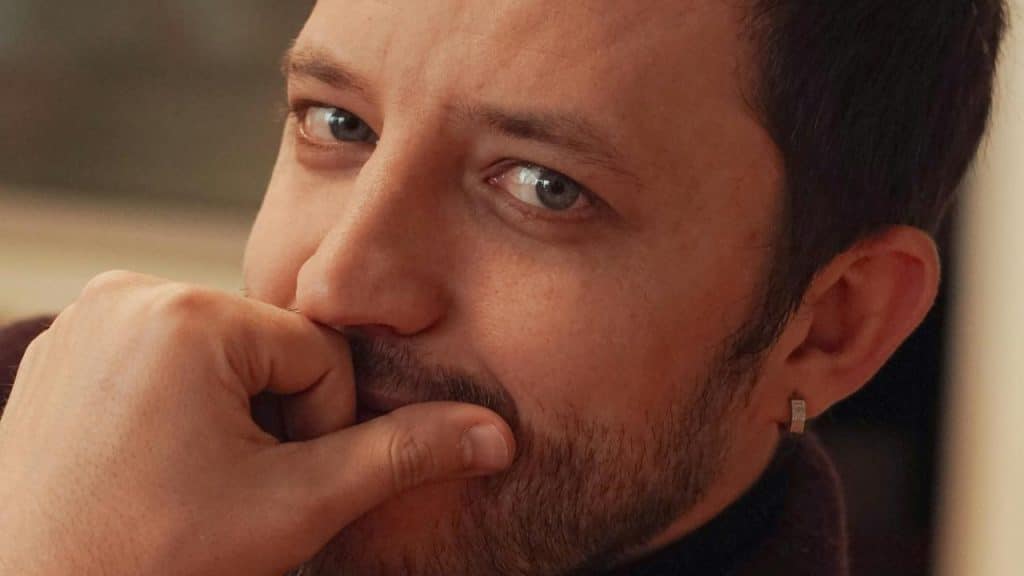 A man rests his hand near his mouth