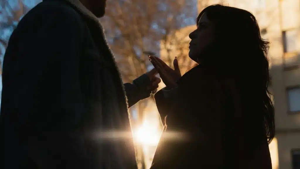 A silhouetted couple arguing outdoors