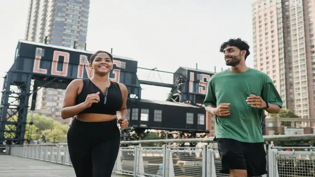 Couple running while the man looks at the woman