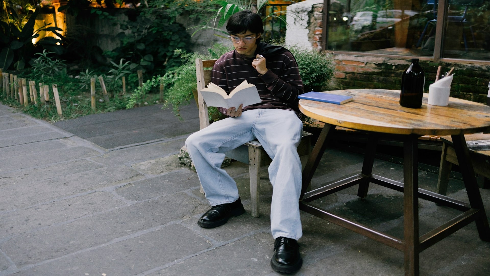 man reading book in café