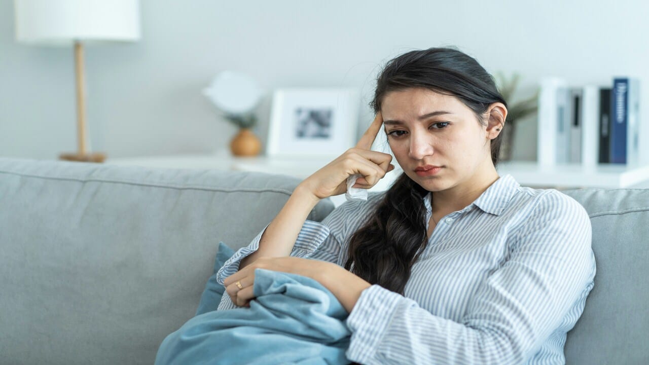 A woman looking sad in the living room