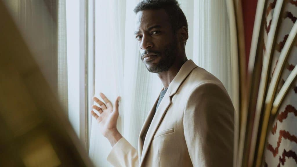A man standing by a window looking outside.