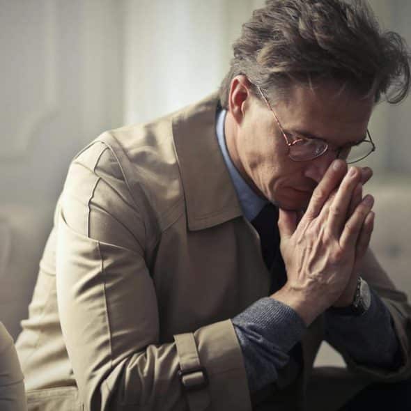 A man sitting with hands clasped