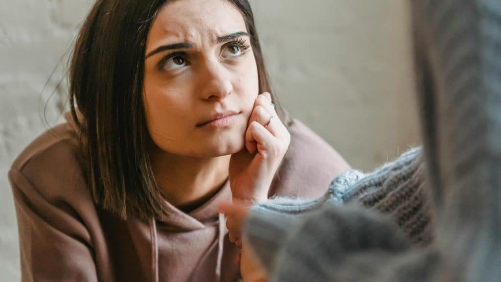 A concerned woman resting her chin on her hand