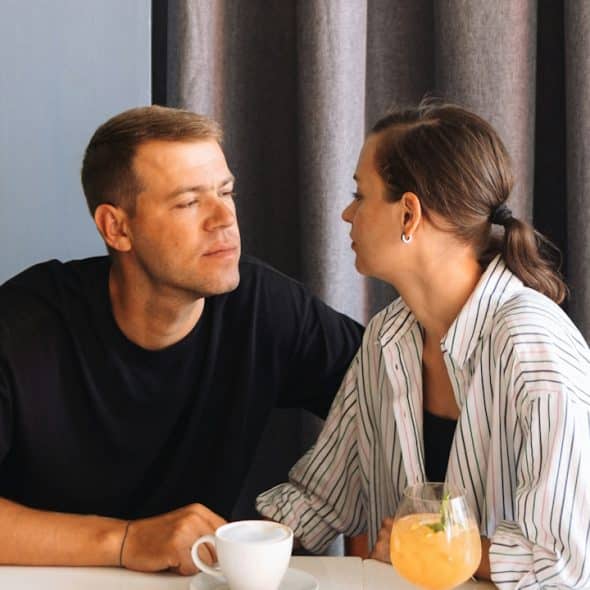 A Couple looking into each other's eyes while sitting at a table.