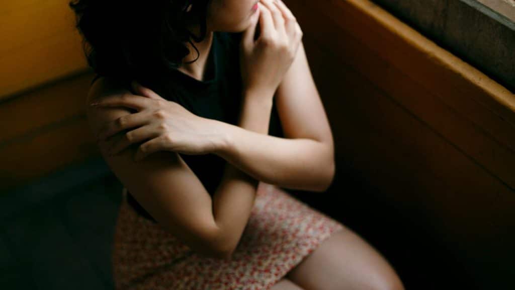 A woman sitting alone with her arms crossed
