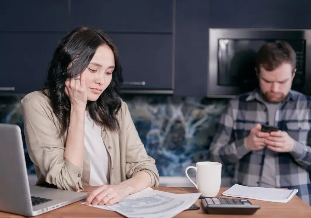 Avoidant man looking at phone from upset wife