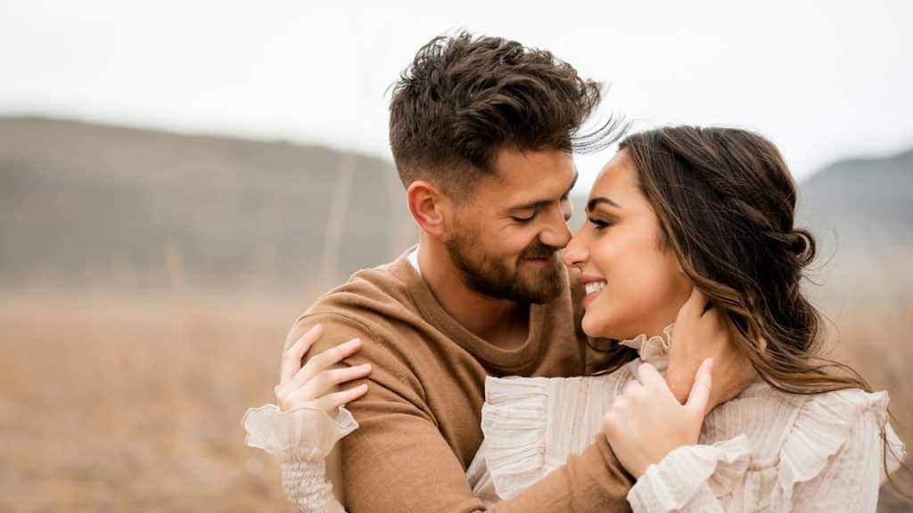 A loving couple embraces and smiles at each other.