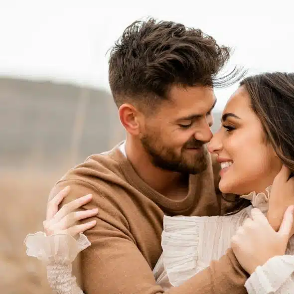 A loving couple embraces and smiles at each other.
