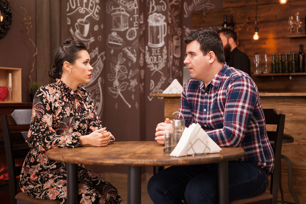 Couple in a restaurant having difficulties conversing