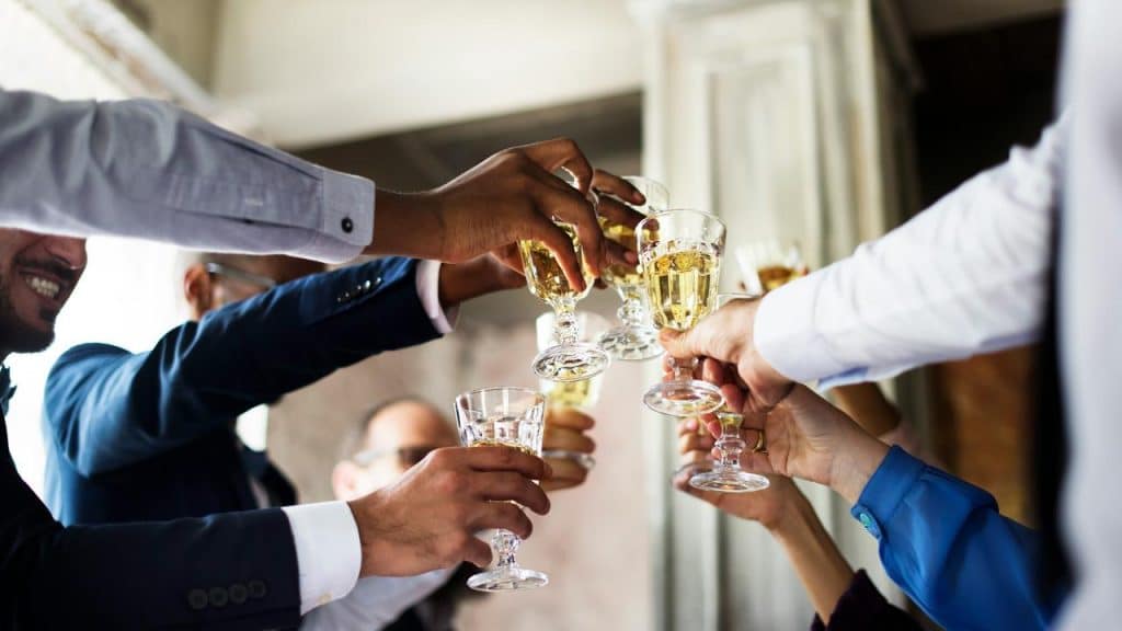A group of people clinking wine glasses together in a celebratory toast.