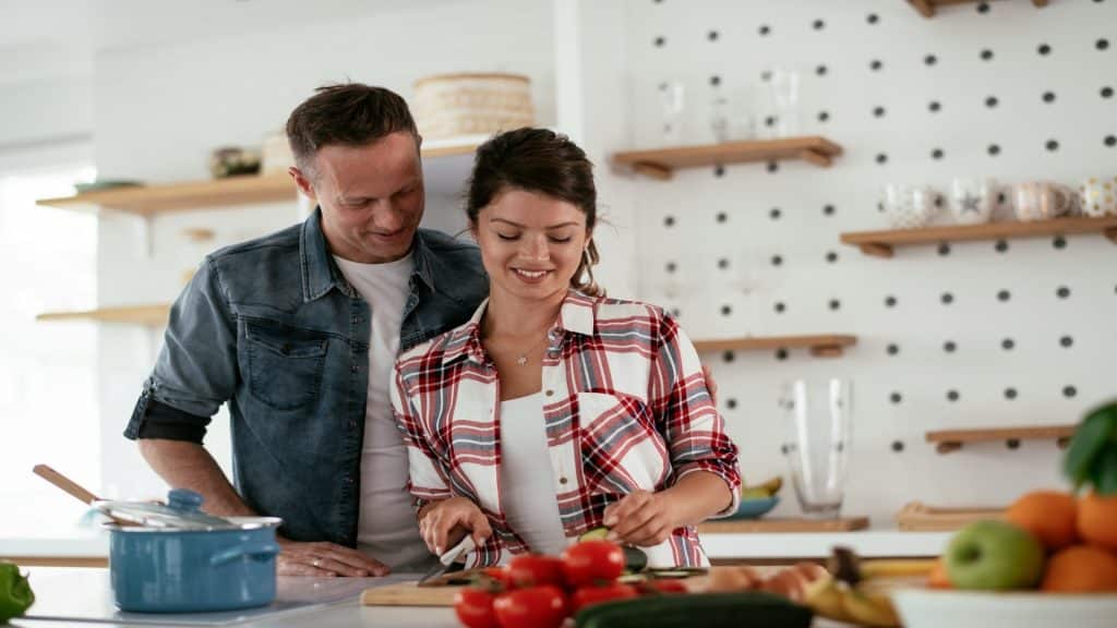 couple cooking together in kitchen