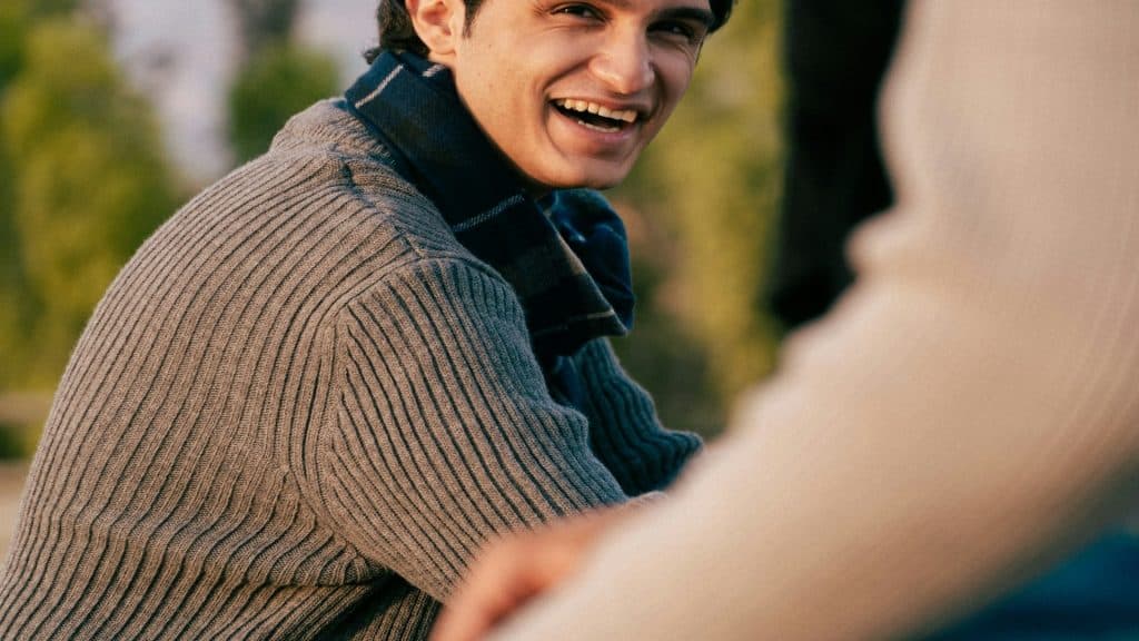 man smiling during conversation with partner
