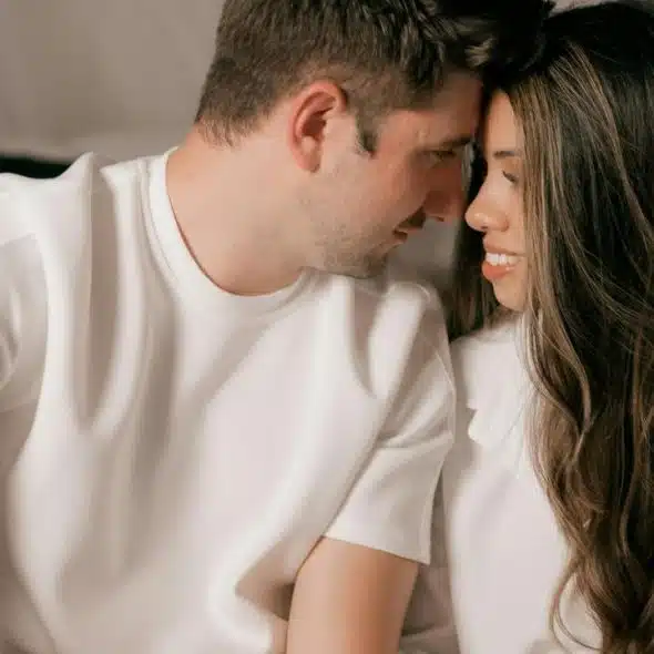 A couple leaning close together, sharing an intimate moment.