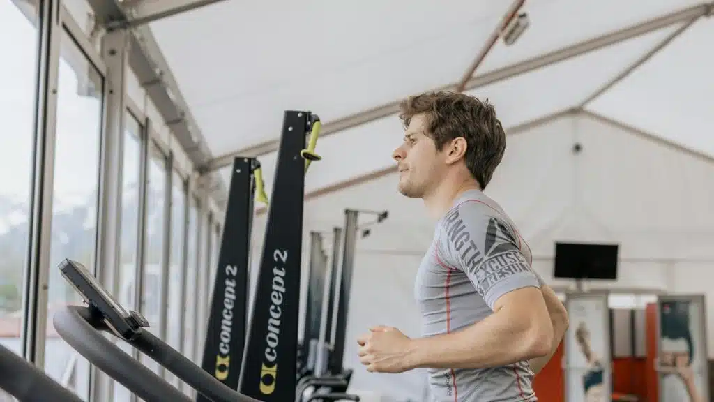 A man runs on a treadmill in a gym.