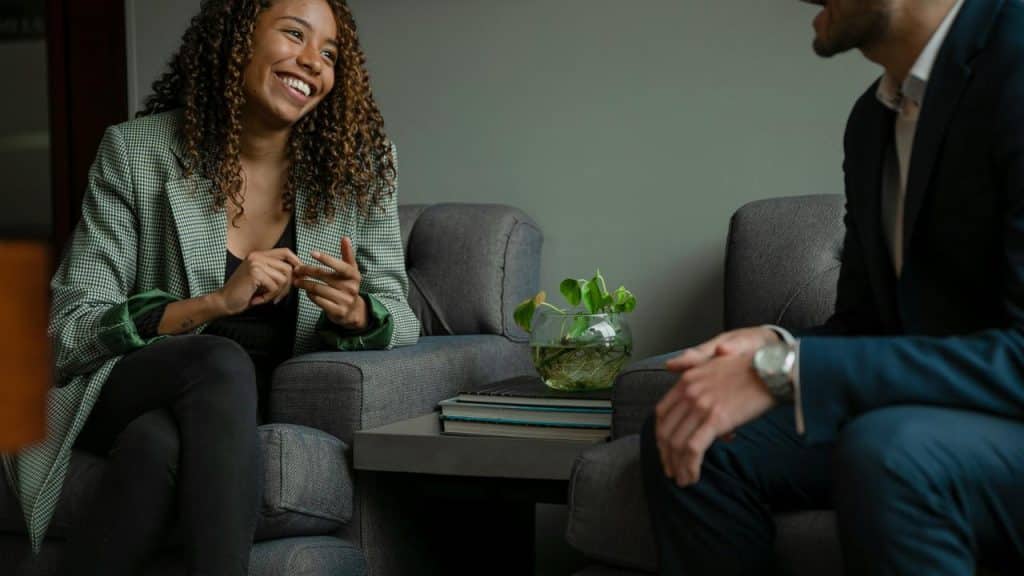 A woman smiling and talking with a man