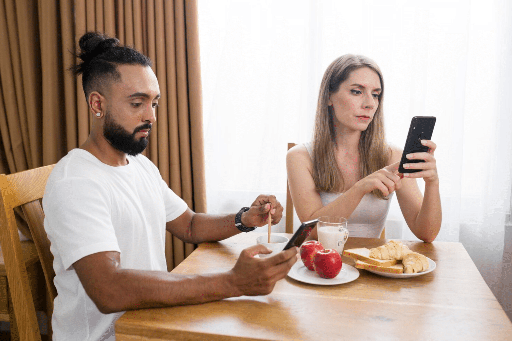 A man and woman busy with their phone during date
