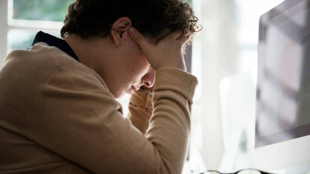 A man holding his head while looking tired and depressed.